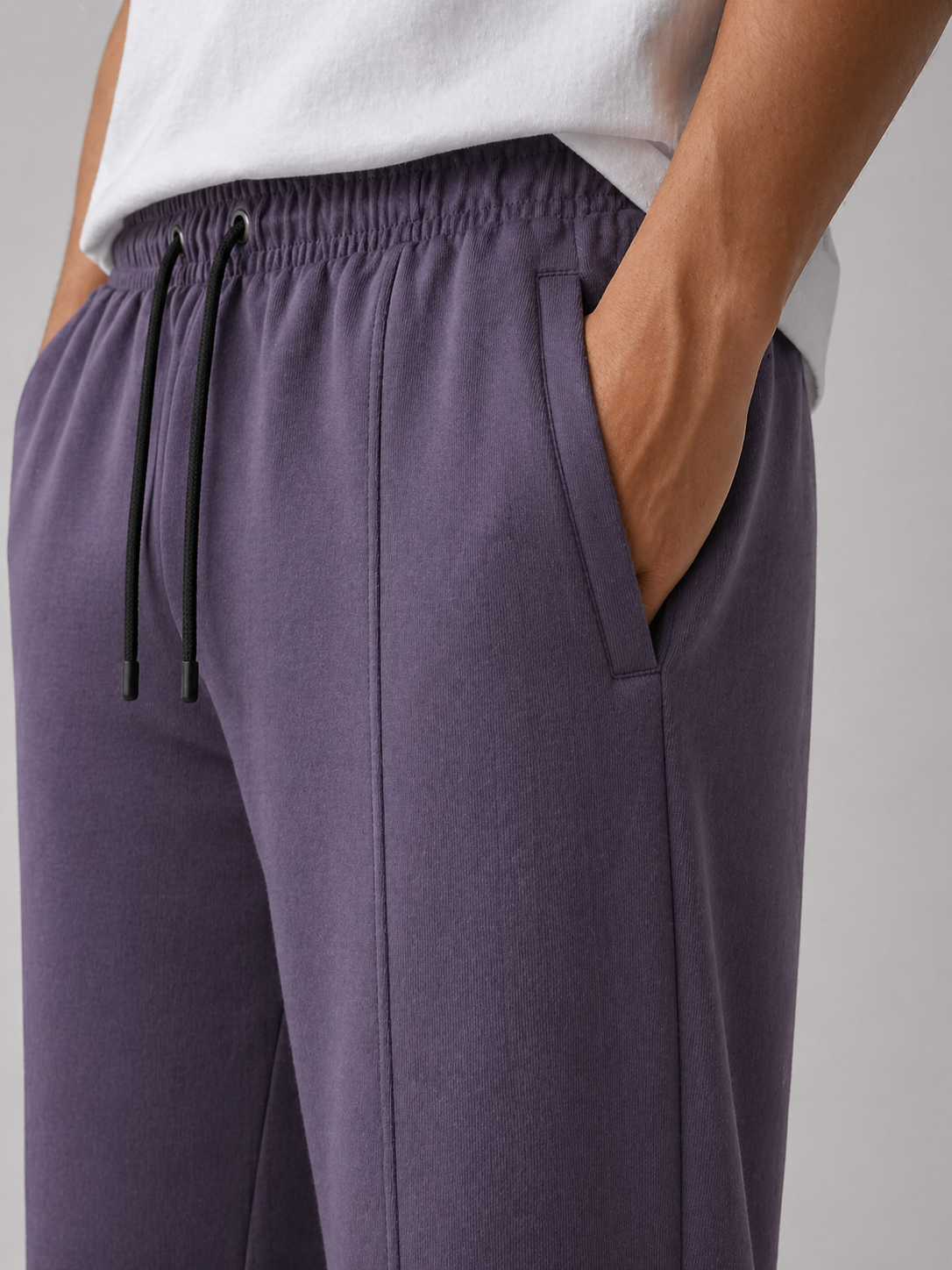 Purple pants with a drawstring waist on a neutral background
