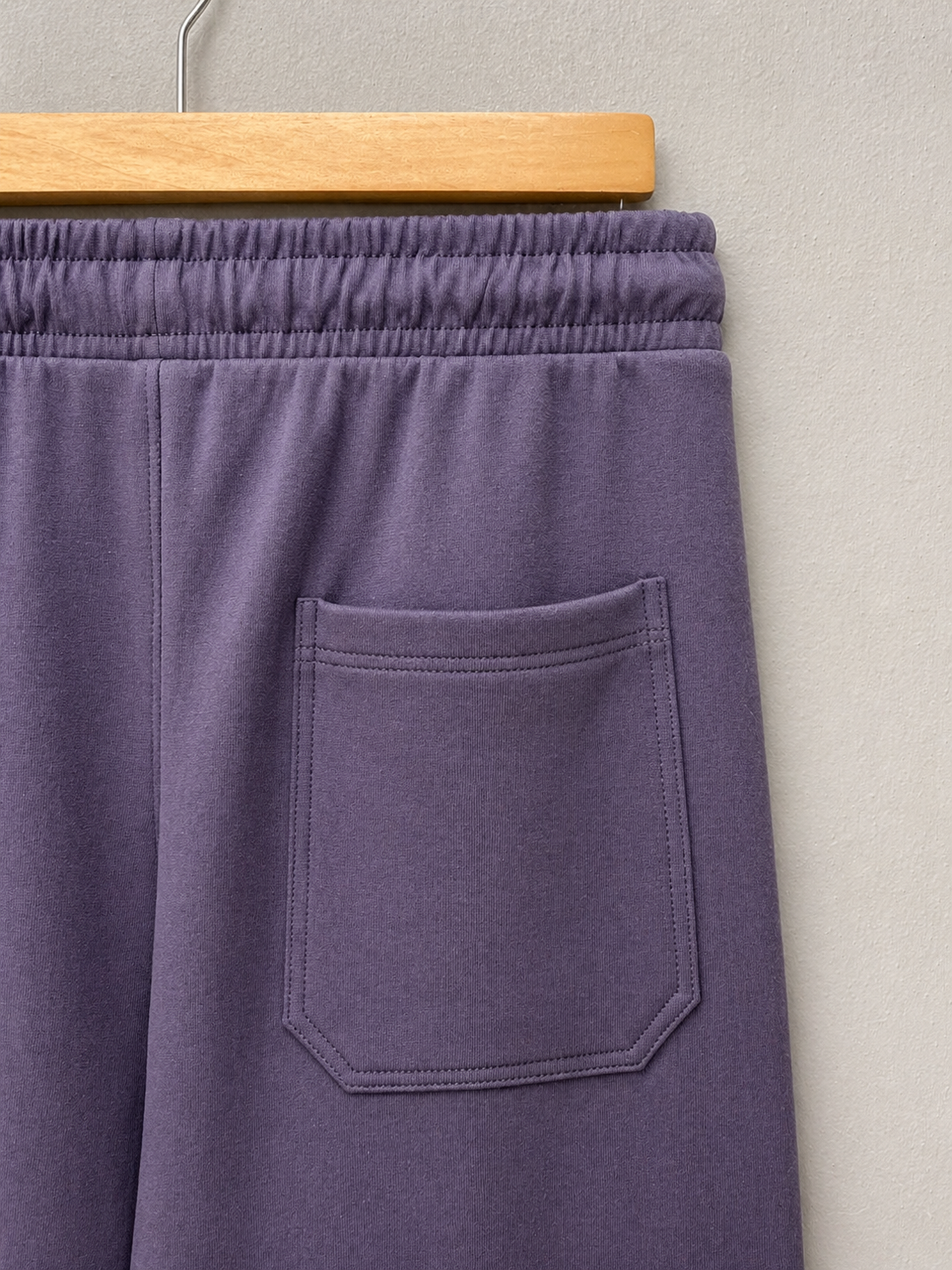 Purple sweatpants with a pocket on a gray background